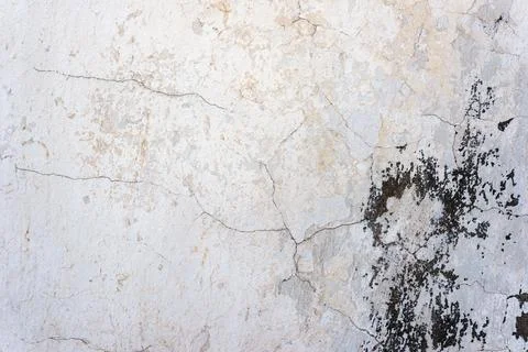 Texture of an old white wall with cracks and dark stains Foto stock