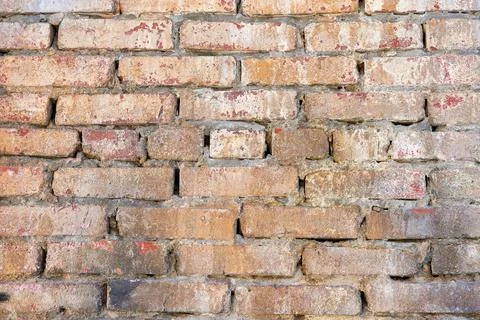 The texture of an old yellow brick wall. Close-up, pattern. Stock Photos