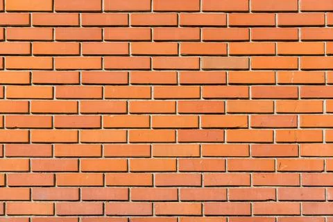 Texture of an orange brick wall, building facade is made of facing brick. Stock Photos