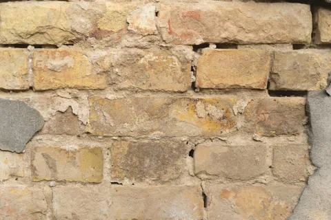 Texture of outer brick wall with old fallen cladding. Old building with falling Stock Photos