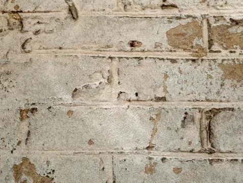 The texture of a part of a light old brick wall with sprinkled plaster Stock Photos