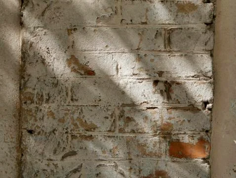 The texture of a part of a light old brick wall with sprinkled plaster Stock Photos