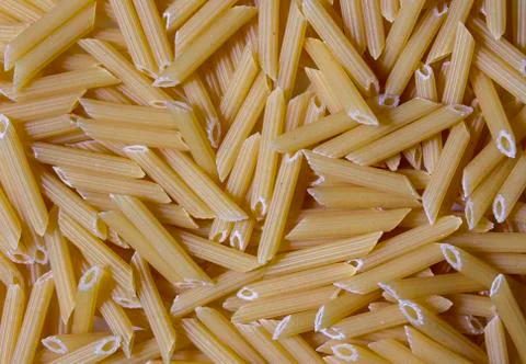 Texture of pasta macaroni from a solid wheat variety light sepia. Italian Stock Photos