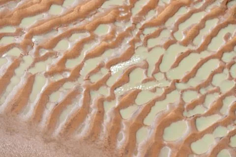 Texture of pattern of sand, mud and water left as tide recedes leaving abst.. Stock Photos