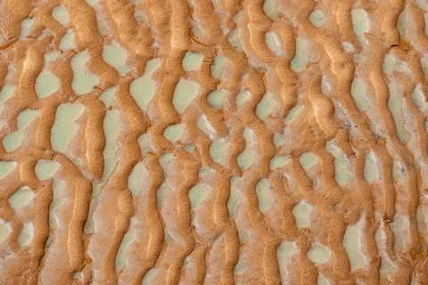 Texture of pattern of sand, mud and water left as tide recedes leaving abst.. Stock Photos