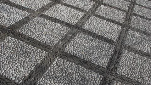 Texture of a pavement of small river pebbles in the form of squares Stock Photos