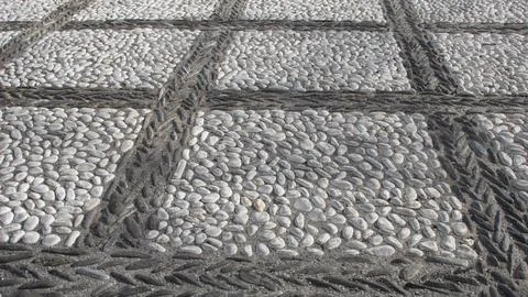 Texture of a pavement of small river pebbles in the form of squares Stock Photos