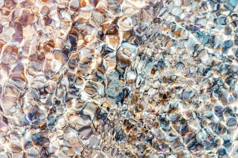 Texture of pebbles through clear glass sea water. Top view, summer background Stock Photos