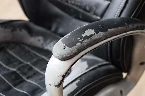 Texture of peeling black leather office chair, closeup Stock Photos