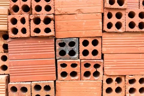 Texture of pile red clay bricks on construction site, close up Stock Photos