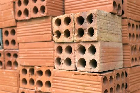 Texture of pile red clay bricks on construction site, close up Stock Photos