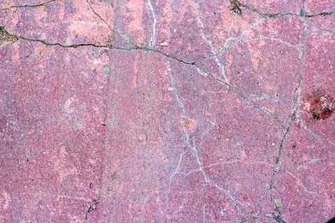 Texture of pink old stone in the cracks filled with soil and moss Foto stock