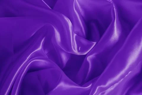The texture of the proton purple cloth with waves and shrugs. Shiny fabric. Stock Photos