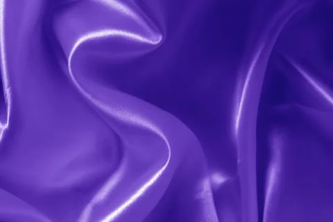 The texture of the proton purple cloth with waves and shrugs. Shiny fabric. Stock Photos