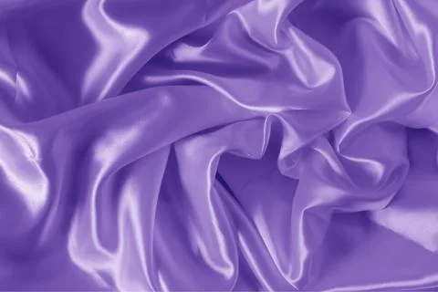 The texture of the proton purple cloth with waves and shrugs. Shiny fabric. Stock Photos
