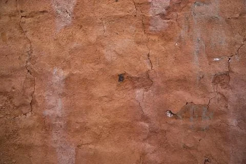 The texture of a red concrete wall with cracks and scratches can be used as a Stock Photos