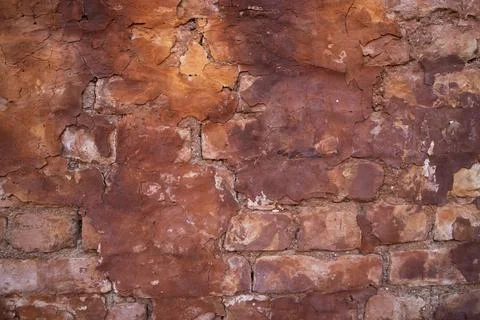 The texture of a red concrete wall with cracks and scratches can be used as a Stock Photos
