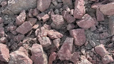 Texture of red limestone stones in sunlight with shadows from leaves Stock Footage 236455617
