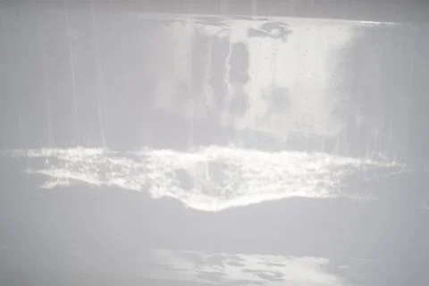 Texture. Reflections of light on the walls of the white bath. Abstraction. Stock Photos