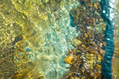 The texture of the river bottom through the water. river pebbles in the water Stock Photos