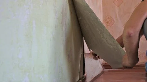 The texture of the room wall in the process of peeling off the wallpaper Stock Photos