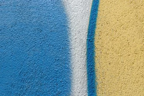 Texture of rough plastered wall painted blue, yellow and white paint. Stock Photos
