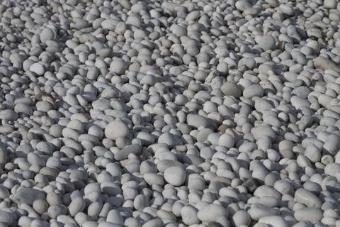 Texture of round and smooth pebbles on the beach of the sea. Stock Photos