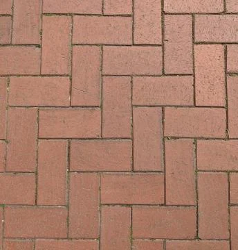 Texture of rust colored brick pavers with grass in between, for background Stock Photos