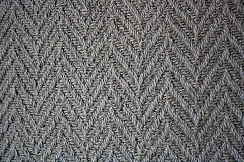 Texture of rustic herringbone fabric in shades of grey. Decorative background Stock Photos