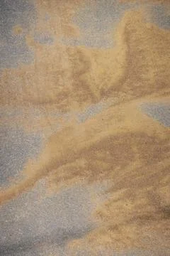 Texture of sand on asphalt. Patterns of wind-blown dry sand on an asphalt roa Stock Photos