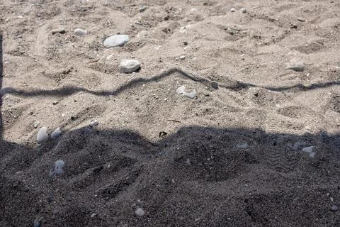 Texture of Sandy Beach With Shadow Patterns From Sun on Warm Summer Day Stock Photos