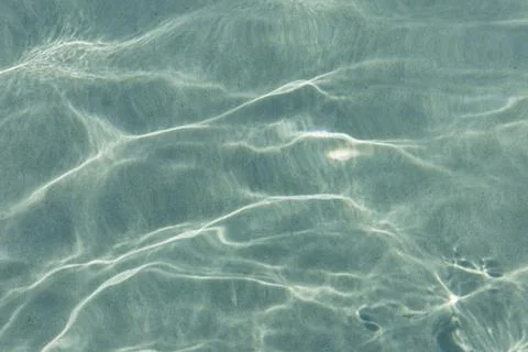 Texture of the sea water surface with small waves and sun reflections. Stock Photos