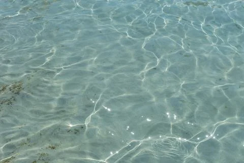 Texture of the sea water surface with small waves and sun reflections. Stock Photos