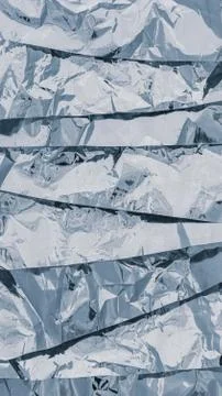 A texture of several layers of shiny silver foil. Vertical background in wint Stock Photos