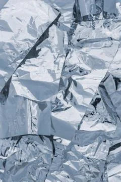 A texture of several layers of shiny silver foil. Vertical background in wint Stock Photos