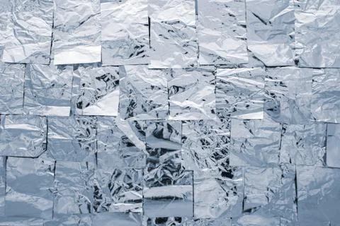 A texture of several layers of shiny silver foil. Vertical background in wint Stock Photos