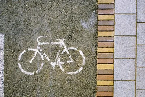 Texture of sidewalk and path with white bicycle sign Stock Photos