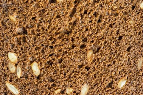 The texture of a slice of black rye bread with seeds. Stock Photos