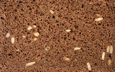 Texture of a slice of bread made from rye flour with sunflower seeds Stock Photos