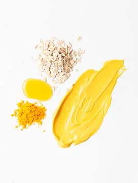 Texture of a smeared face mask made of turmeric, honey and oatmeal flour Stock Photos