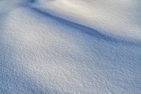Texture of snow illuminated by sunlight. Stock Photos