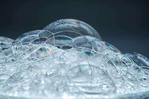 The texture of soap bubbles and foam in close-up on a blue background. Foto stock