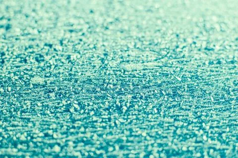 Texture of sparkling first cold ice. Snowy backdrop in green colors. Winter b Stock Photos