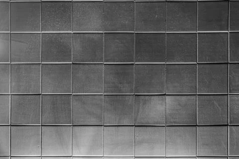 The texture of square glossy uneven ceramic tiles. Bottom hard dark lighting. Stock Photos