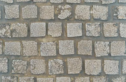 The texture of the stone pavement. Granite square cobblestone pavement. Stock Photos