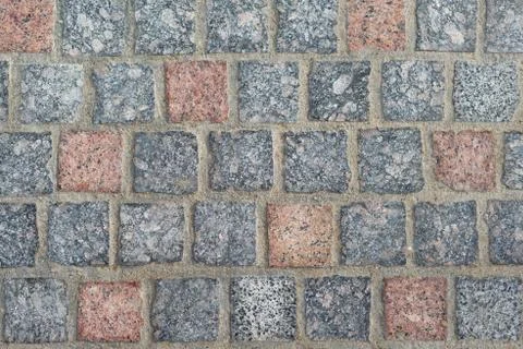 Texture. stone paving of square granite stones of gray and reddish colors Stock Photos