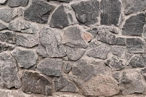 Texture of a stone wall background. part of a stone wall. Stock Photos