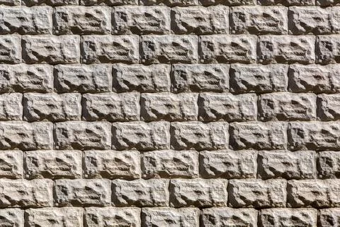 Texture of a stone wall with rustication, masonry made of natural stone. Stock Photos