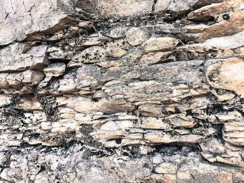 The texture of the stone wall of sharp cracked convex rough natural gray puff Stock Photos