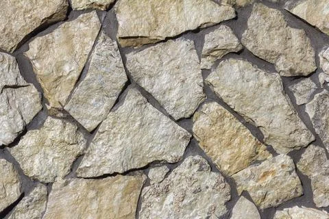 The texture of a stone wall. A stone wall as a background or texture. Stock Photos